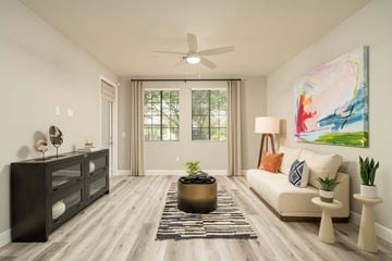 Phoenix apartment for rent - A living room with a beige sofa, a black dresser, and a painting on the wall.