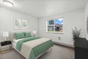 Tacoma apartment for rent - A bedroom with a large bed and a window overlooking a building.