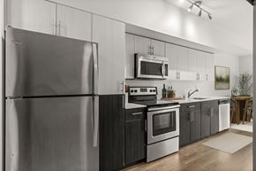 Seattle apartment for rent - A modern kitchen with a stainless steel refrigerator and black cabinets.
