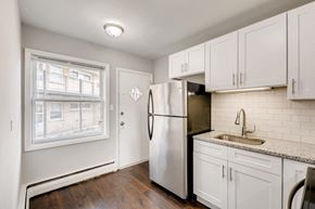 Arlington Heights apartment for rent - A kitchen with white cabinets and a stainless steel refrigerator.