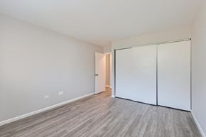 Schaumburg apartment for rent - a bedroom with white walls and wood flooring and a closet