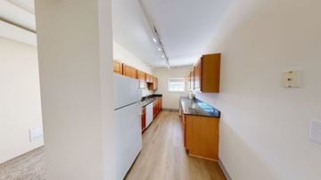 Evanston apartment for rent - A kitchen with white cabinets and a white fridge.