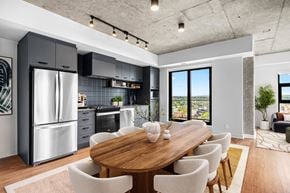 Calgary apartment for rent - Suite 2502 - A modern kitchen with a wooden dining table and chairs.