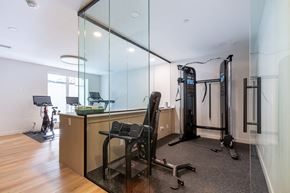 Calgary apartment for rent - A home gym with a variety of equipment including a treadmill, weights, and a stationary bike.