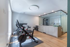Calgary apartment for rent - A modern home gym with a stationary bike and a glass wall.