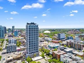 Calgary apartment for rent - A cityscape with a tall building in the foreground and other buildings in the background.