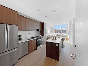 Calgary apartment for rent - a large kitchen with stainless steel appliances and wooden cabinets