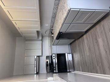 Washington apartment for rent - A modern kitchen with a stainless steel refrigerator and a white countertop.