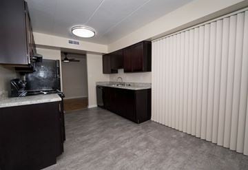 Laurel apartment for rent - A kitchen with dark brown cabinets and a white countertop.