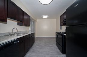 Laurel apartment for rent - A kitchen with black appliances and brown cabinets.