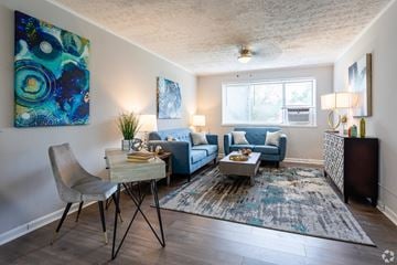 Greenbelt apartment for rent - A living room with a blue couch and a white chair.