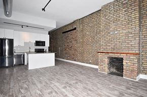 Chicago apartment for rent - A room with a brick wall and a fireplace.