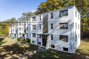 Greenbelt apartment for rent - A white apartment building with a green lawn in front.