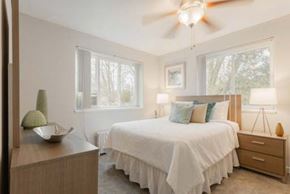 Greenbelt apartment for rent - A bedroom with a bed, nightstand, and a ceiling fan.
