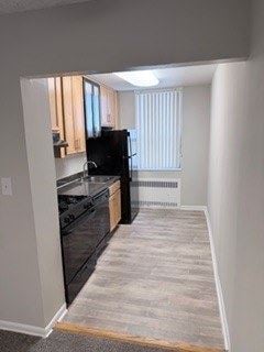 Laurel apartment for rent - A black refrigerator is in a kitchen with white walls.