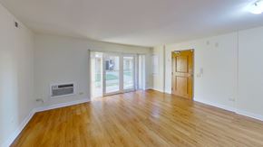 Riverdale apartment for rent - an empty living room with wood floors and a door to a balcony