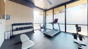 Chicago apartment for rent - a gym with a treadmill and weights on the floor