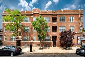 Chicago apartment for rent - a brick building with cars parked in front of it