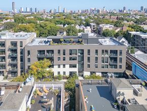 Chicago apartment for rent - an aerial view of a building with a green roof and a city in the background