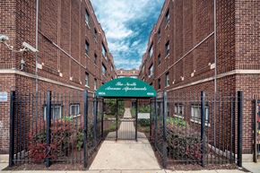 Chicago apartment for rent - the entrance to an alleyway between two brick buildings with a green awning