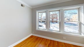 Chicago apartment for rent - a bedroom with three windows and a wood floor