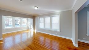 Chicago apartment for rent - an empty living room with a hard wood floor and three windows