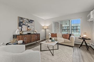 Riverview apartment for rent - A modern living room with a white sofa, a coffee table, and a large painting on the wall.