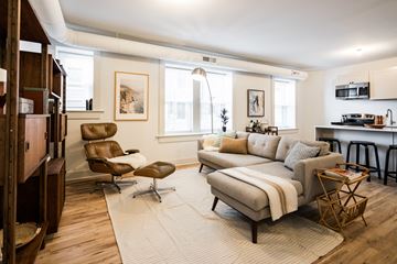 Detroit apartment for rent - A living room with a brown leather chair and a white couch.