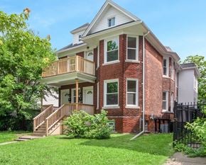 Detroit triplex for rent - A red brick house with a white porch.