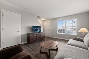 Monroe apartment for rent - A living room with a brown couch, a wooden coffee table, and a television.