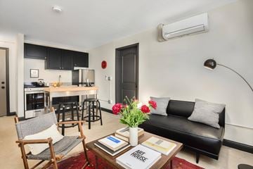 Detroit apartment for rent - A black couch sits in a living room with a coffee table in front of it.
