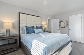Newport apartment for rent - A bedroom with a large bed and a mirror on the wall.