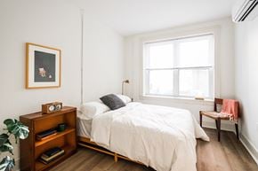 Detroit apartment for rent - A bedroom with a bed, nightstand, and a window.