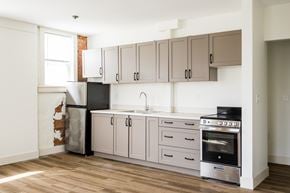 Detroit apartment for rent - A kitchen with a refrigerator, oven, and cabinets.