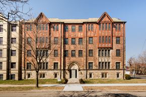 Detroit apartment for rent - A large red brick building with a tree in front of it.