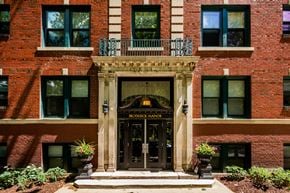Detroit apartment for rent - A red brick building with a black door and windows.