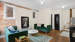 Detroit apartment for rent - a living room with two green couches and a fireplace