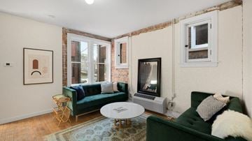 Detroit apartment for rent - a living room with two green couches and a fireplace