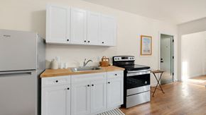 Detroit apartment for rent - a kitchen with white cabinets and a stove and a refrigerator