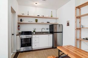 Detroit apartment for rent - a small kitchen with white cabinets and stainless steel appliances