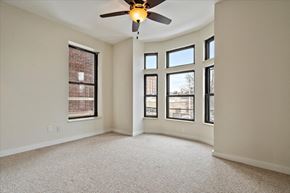 Detroit apartment for rent - an empty room with a ceiling fan and five windows