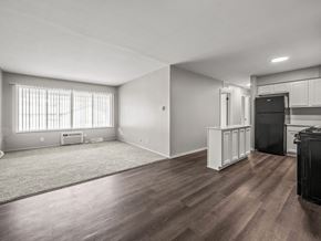 Ypsilanti apartment for rent - an empty living room with a kitchen in the background