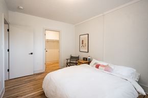Detroit apartment for rent - A bedroom with a large bed and a chair.