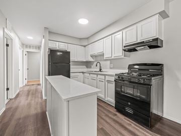 Ypsilanti apartment for rent - the kitchen of a new home with white cabinets and black appliances
