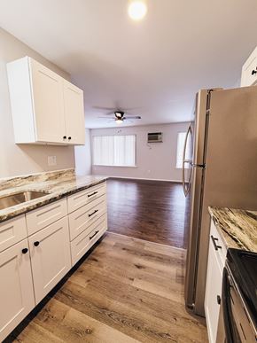 Ferndale apartment for rent - a kitchen with white cabinets and a hard wood floor and a refrigerator