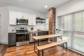 Detroit townhouse for rent - A kitchen with a wooden table and bench seating.