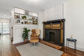 Detroit townhouse for rent - A living room with a fireplace and a chair.