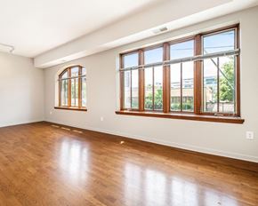Detroit apartment for rent - an empty living room with hardwood floors and large windows