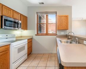 Detroit apartment for rent - a kitchen with white appliances and wooden cabinets
