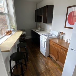 Detroit apartment for rent - a kitchen with a stove and a counter with stools